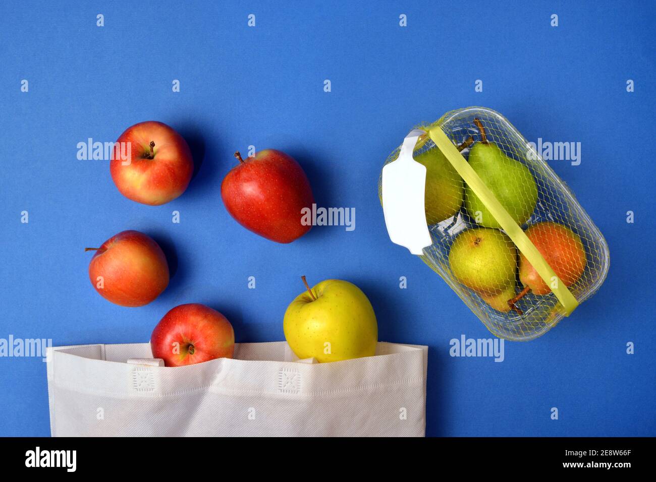 Détail des fruits achetés dans un emballage en plastique et réutilisables sacs en tissu Banque D'Images