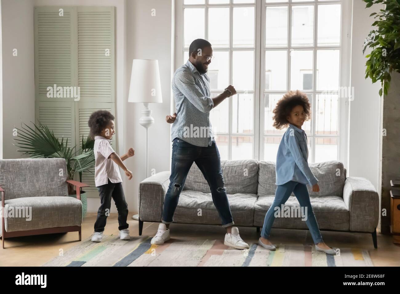 Grand père afro-américain avec enfants dansant à la maison Banque D'Images