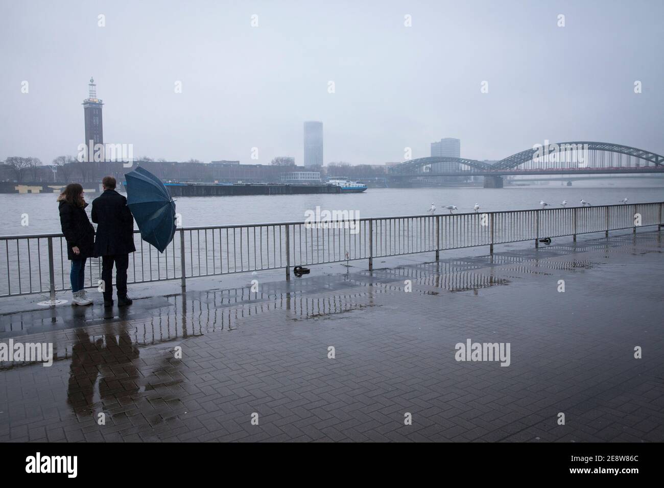 Un couple sous la pluie sur les rives du Rhin, en regardant vers le quartier de la ville Deutz et le pont Hohenzollern, Cologne, Allemagne. ein Paar BEI R. Banque D'Images