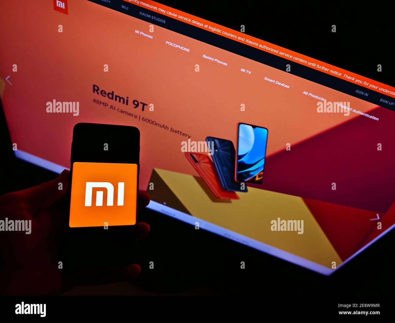 Vue en grand angle de la personne tenant un téléphone portable avec le logo de la société chinoise d'électronique Xiaomi Corporation. Mise au point sur l'écran du téléphone mobile. Banque D'Images