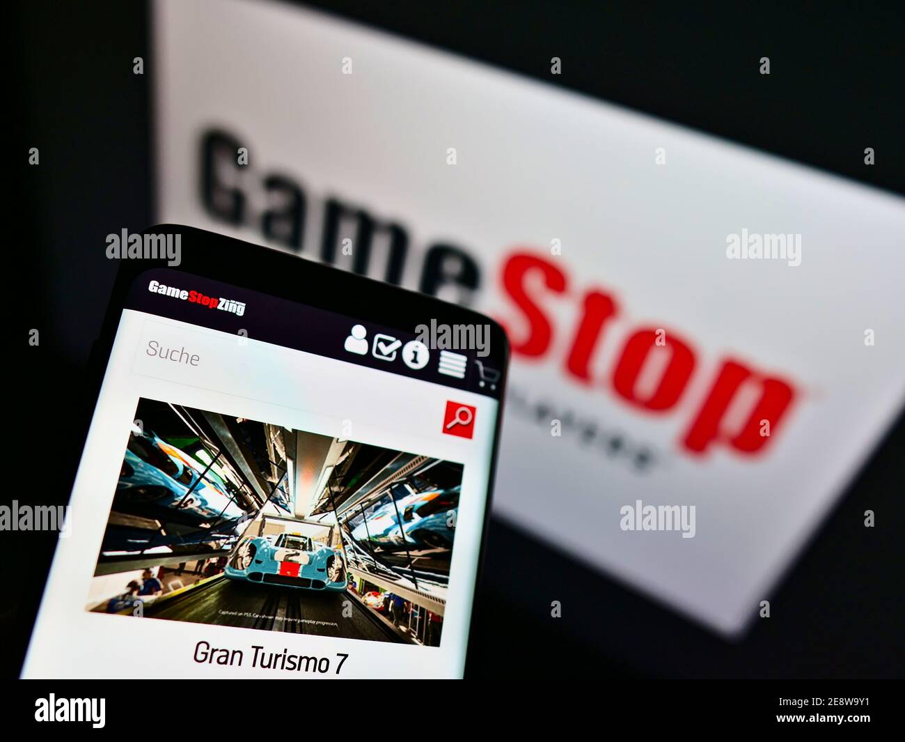 Smartphone avec boutique en ligne de la société de vente GameStop Corp. (Jeux vidéo) en face du logo de l'entreprise. Mise au point au centre de l'écran du téléphone. Banque D'Images