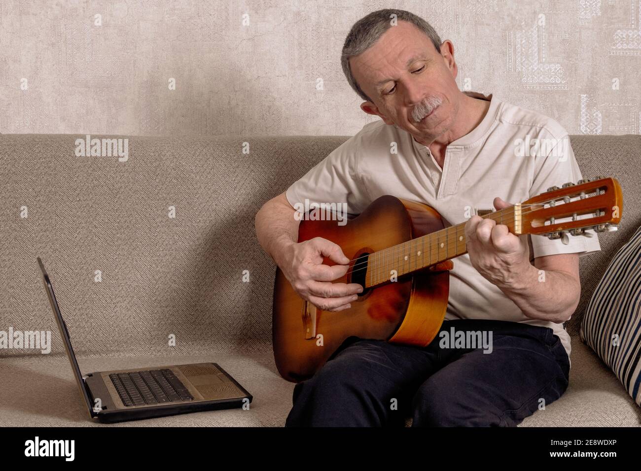 Un homme âgé apprend à jouer de la guitare à distance par chat vidéo. Leçon  de guitare en ligne. Blogueur. Mise au point sélective Photo Stock - Alamy