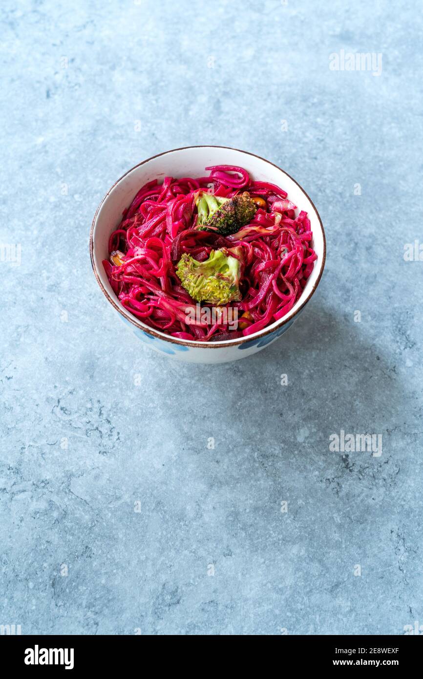 Betterave à betteraves nouilles de riz thaï aromatisées à la betterave et brocoli dans un bol. Prêt à manger et à servir. Banque D'Images