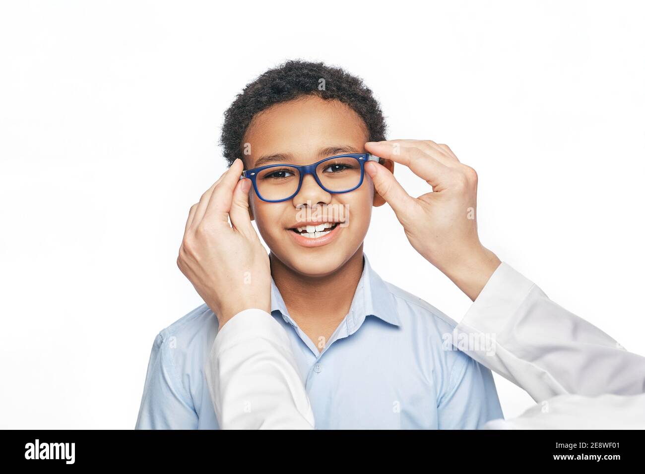 Ophtalmologiste essaie de lunettes à un petit garçon afro-américain, gros plan. Traitement de la vision des enfants avec des lunettes Banque D'Images