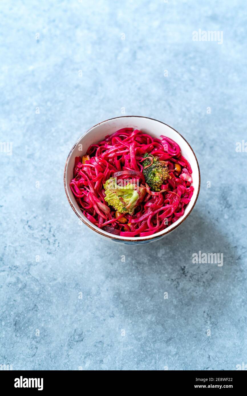 Betterave à betteraves nouilles de riz thaï aromatisées à la betterave et brocoli dans un bol. Prêt à manger et à servir. Banque D'Images