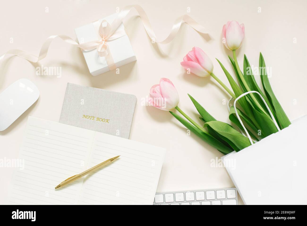 Tulipes, boîte cadeau et café sur fond beige. Pose à plat. 8 mars, Journée internationale de la femme. Saint Valentin. Le lieu de travail de Blogger Banque D'Images