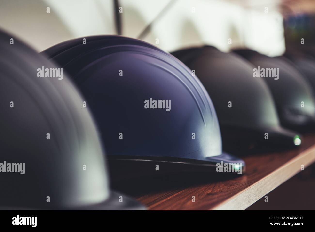 Rangée de casques d'équitation neufs sur le rack de magasin Riders. Casque de protection pour plus de confiance et de sécurité lors de la balade à cheval. Banque D'Images