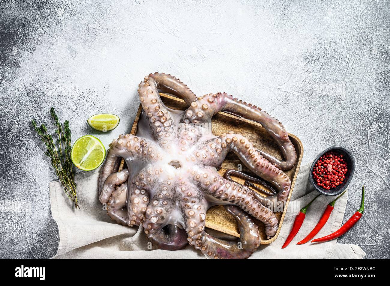 Pieuvre crue dans un bol. Fruits de mer biologiques. Arrière-plan gris. Vue de dessus. Copier l'espace Banque D'Images
