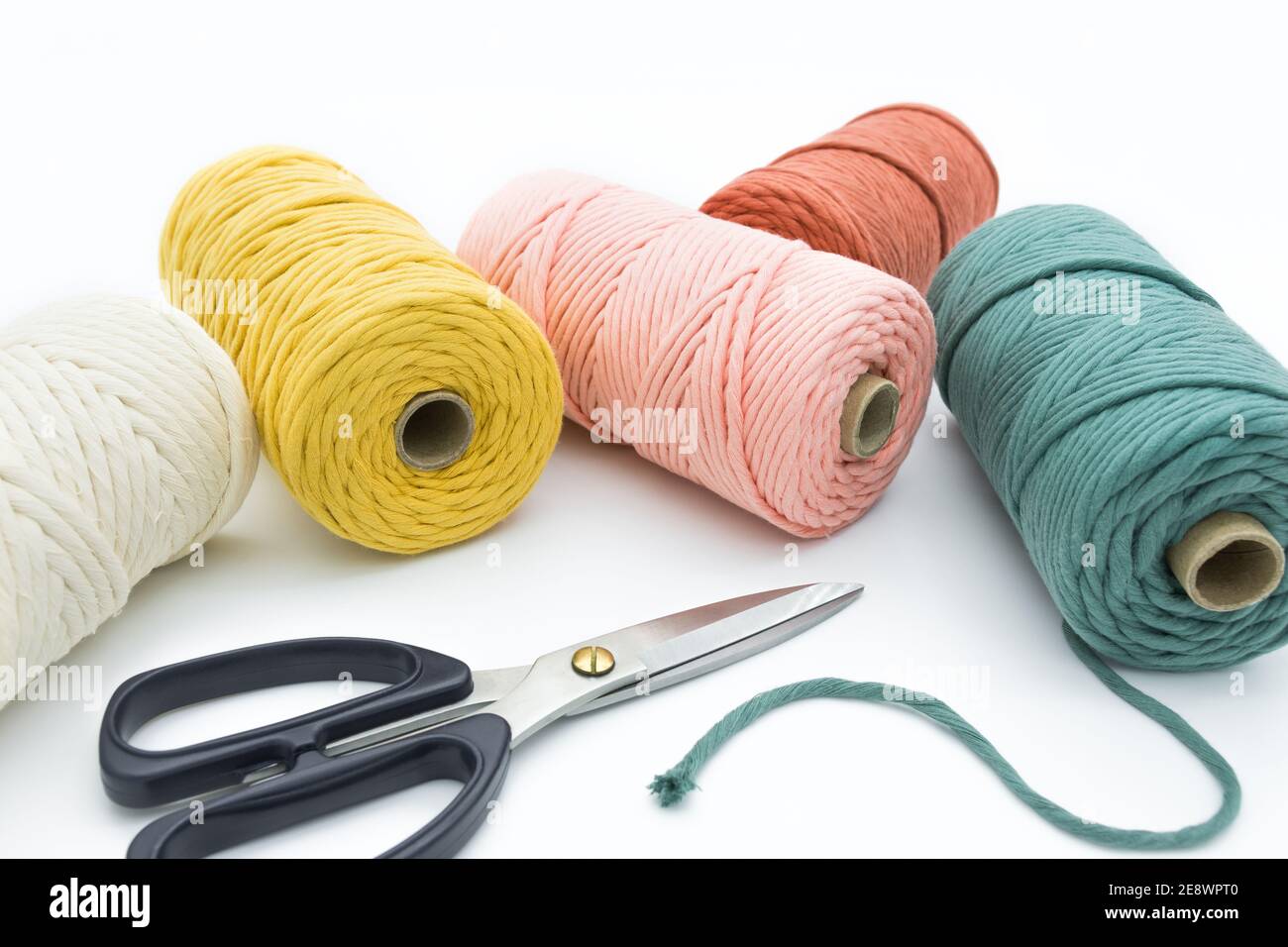 Vue rapprochée des cordons et ciseaux en coton à une rangée de couleurs pour les artisanes de macrame. Banque D'Images