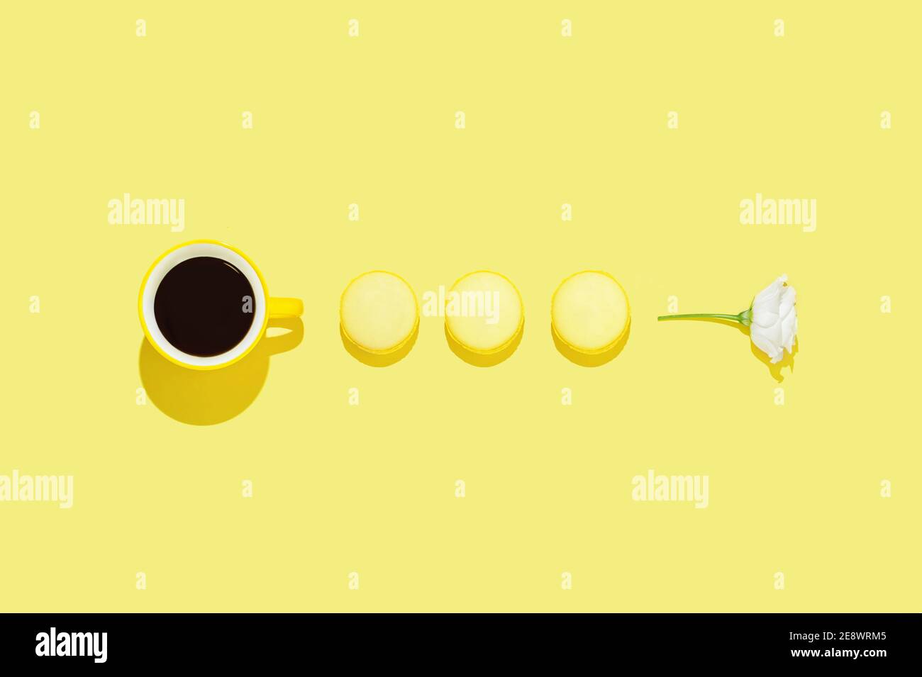 Arrangement créatif avec une tasse de café sur fond jaune vif. Concept moderne et minimaliste du bon matin. Saint-Valentin ou arrière-plan de la femme. Banque D'Images