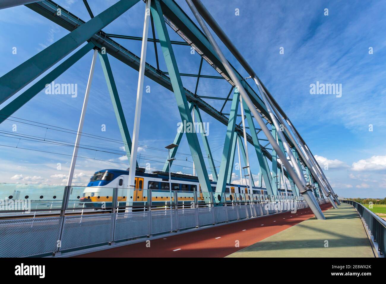 Train de voyageurs néerlandais passant par un pont à Nimègue, dans le Gelderland Banque D'Images