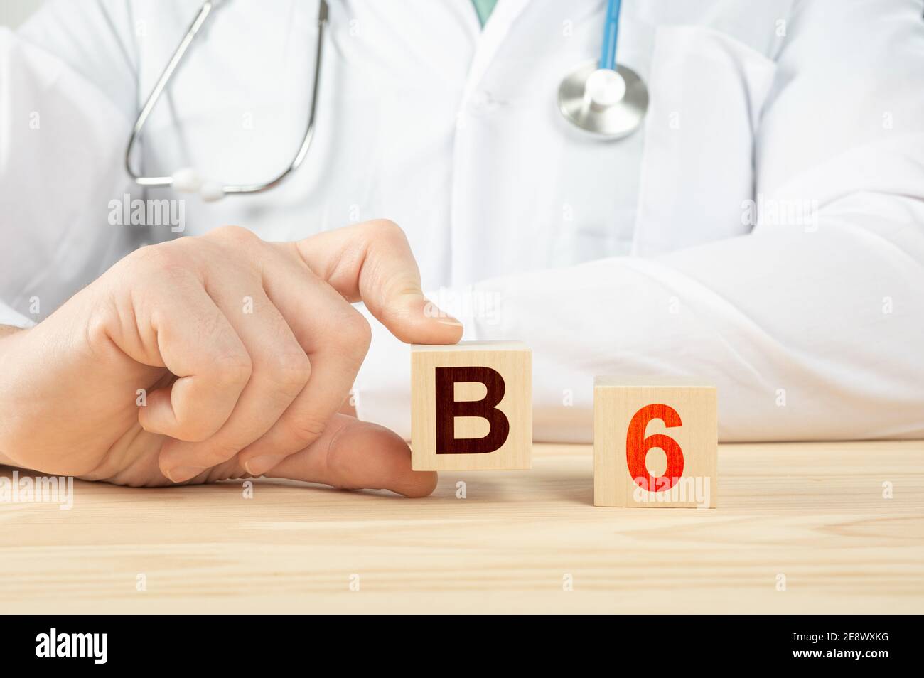 le médecin recommande de prendre de la vitamine b12. le médecin parle des avantages de la vitamine b6. Vitamine - concept de santé. Alphabet B6 sur cube en bois. Tient la main a Banque D'Images