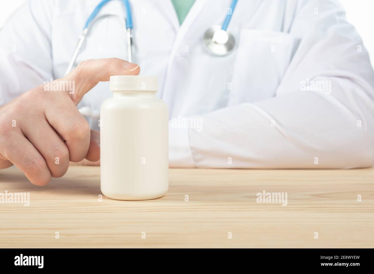 le médecin recommande de prendre des médicaments, des suppléments, des vitamines, des suppléments alimentaires. Praticien avec bouteille de pilules. Flacon de pilules en plastique blanc sur le docteur woode Banque D'Images