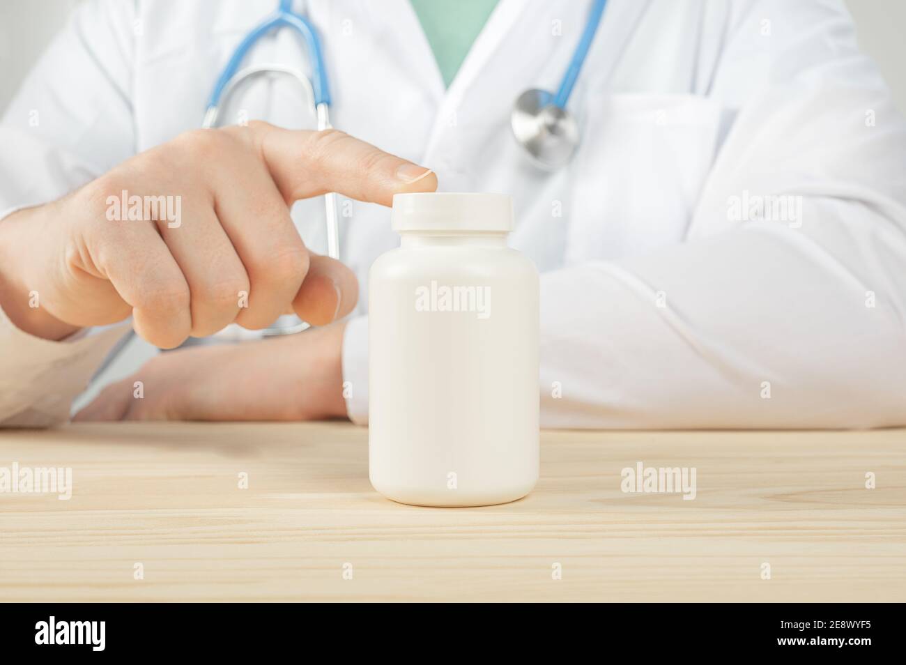 médecin tenant une bouteille de comprimés ou de comprimés avec une étiquette blanche vierge pour le traitement d'une maladie ou d'une blessure. le médecin prescrit un médicament. Médecin montrant B Banque D'Images