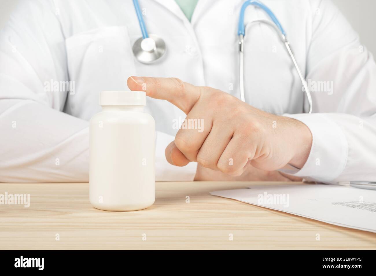 le médecin recommande de prendre des médicaments, des suppléments, des vitamines, des suppléments alimentaires. Praticien avec bouteille de pilules. Flacon de pilules en plastique blanc sur le docteur woode Banque D'Images