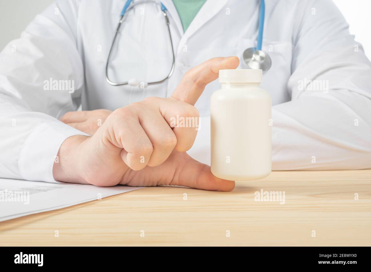 Flacon de pilules dans les mains du médecin de près. Le médecin prescrit un médicament au patient. Médecin prescrivant des médicaments assis au bureau à l'extérieur Banque D'Images