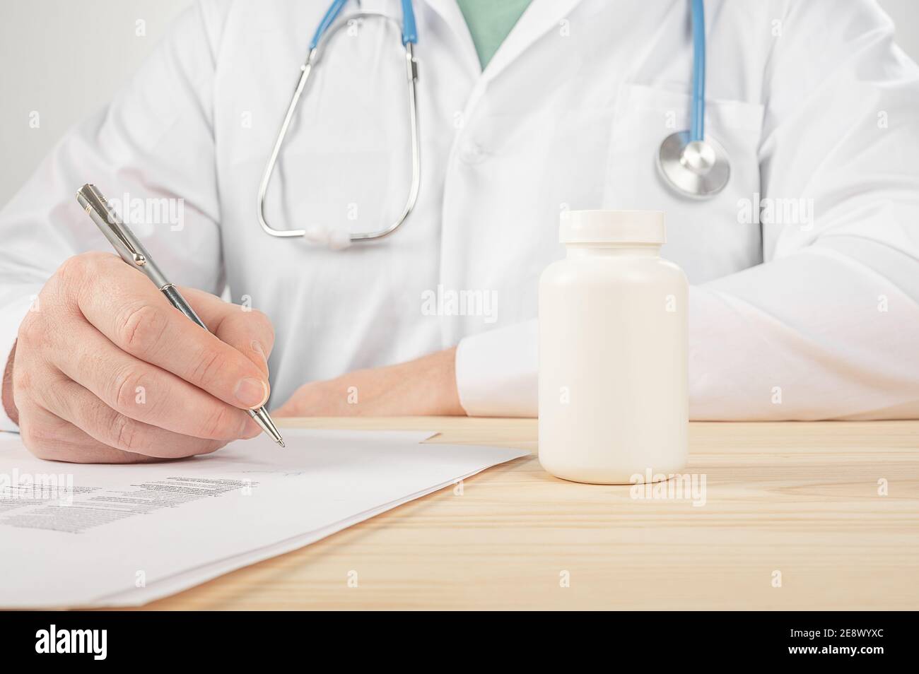 Médecin spécialiste en médecine des hommes de main tenir pot de pilules et d'écrire d'ordonnance à un patient à la table de travail. Panacée et économiser en prescrire un traitement drogue légale sto Banque D'Images