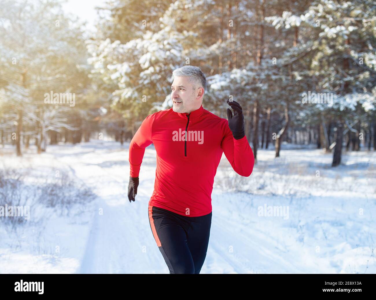 Concept de course par temps froid. Faites du jogging avec des vêtements de sport dans un parc hivernal enneigé. Entraînement saisonnier Banque D'Images