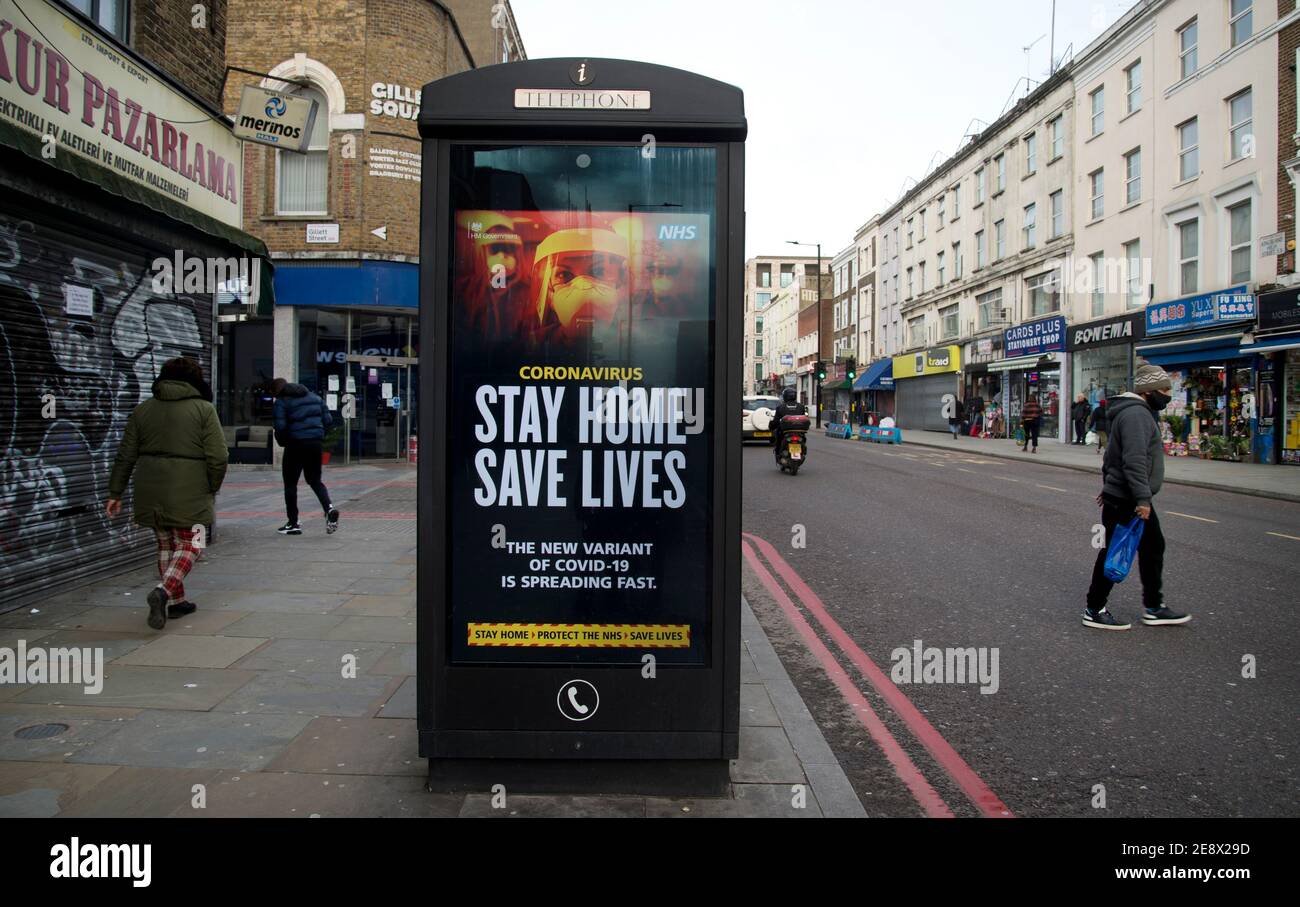 Hackney, Londres, Royaume-Uni. Hiver. Vide Kingsland High Street et affiche du gouvernement pour dire à deux personnes : « faites maison, sauvez des vies ». Banque D'Images