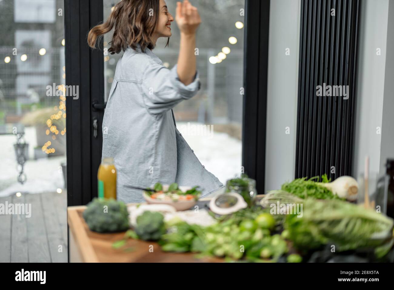 Femme dansant dans la cuisine à la maison Banque D'Images