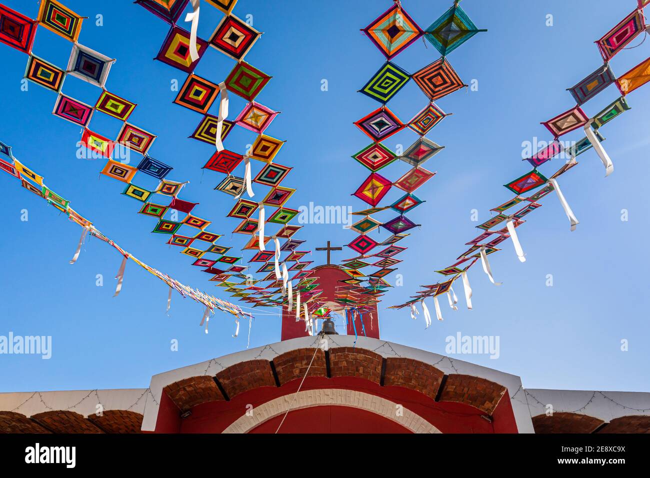 Des bannières Huichol colorées appelées 'Ojos de Dios' décorent une église à Sayulita, Nayarit, Mexique. Banque D'Images