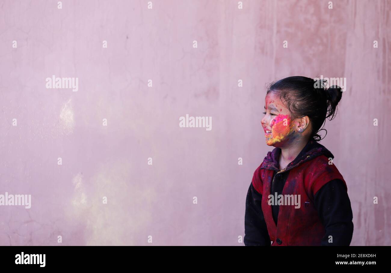 Petite fille jouant avec des couleurs Holi concept avec l'espace négatif Banque D'Images
