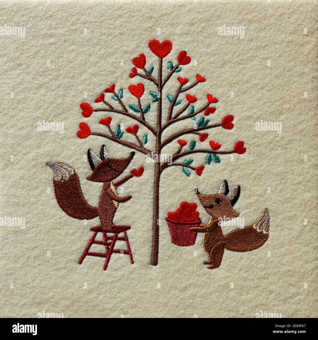 Broderie de la Saint-Valentin; 2 renards tailler l'arbre avec les coeurs rouges; mignon; amour; artisanat; tissu en feutre crème, PR Banque D'Images