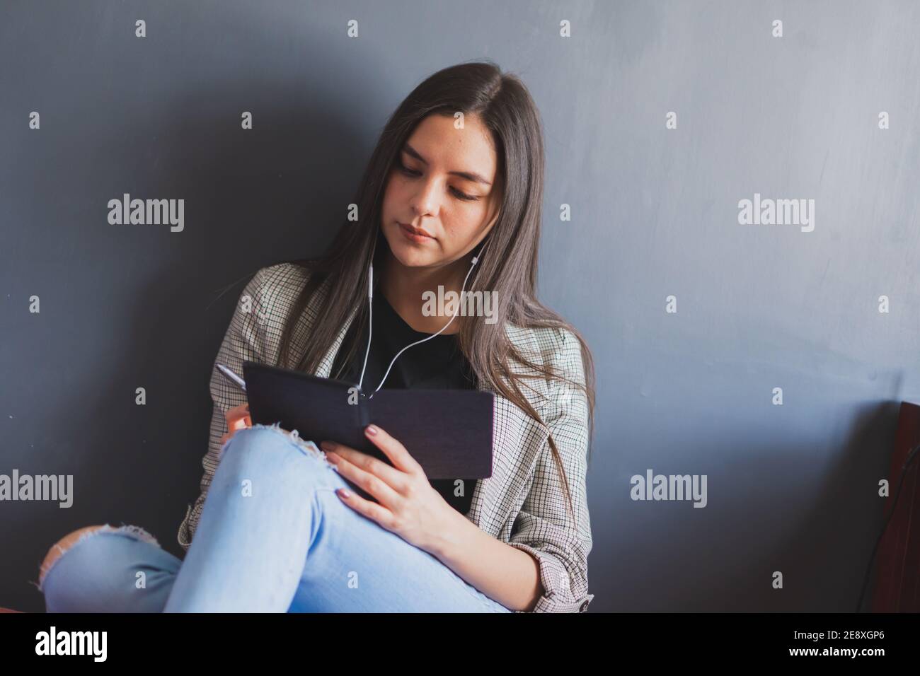 Jeune femme lisant un livre électronique. Prendre des notes de tout ce que vous apprenez. Banque D'Images