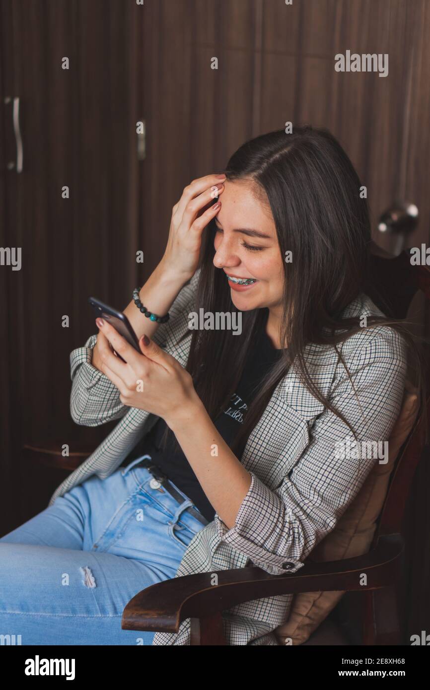 Jeune femme vérifiant et tapant sur son téléphone cellulaire. Vérifier leurs réseaux sociaux et publier des photos. Banque D'Images