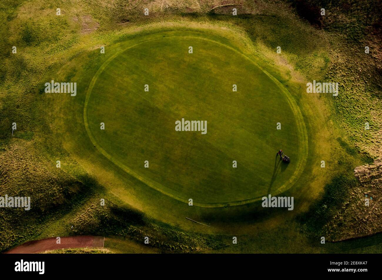 Gardien au club de golf de Wallasey, Wirral tond le green lors de l'enfermement le 1er février 2021. Les clubs de golf autour du Royaume-Uni restent sous le strict Tsul Banque D'Images