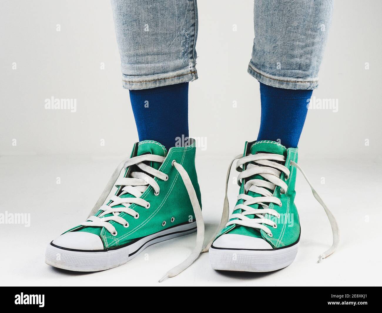 Baskets vertes élégantes et chaussettes drôles sur fond blanc. Concept de  mode, de beauté et de bonne humeur Photo Stock - Alamy