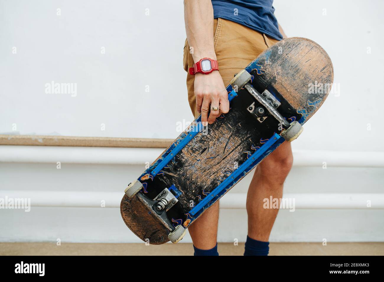 Homme élégant tenant la planche avec ses doigts. Écourté, sans tête. Banque D'Images