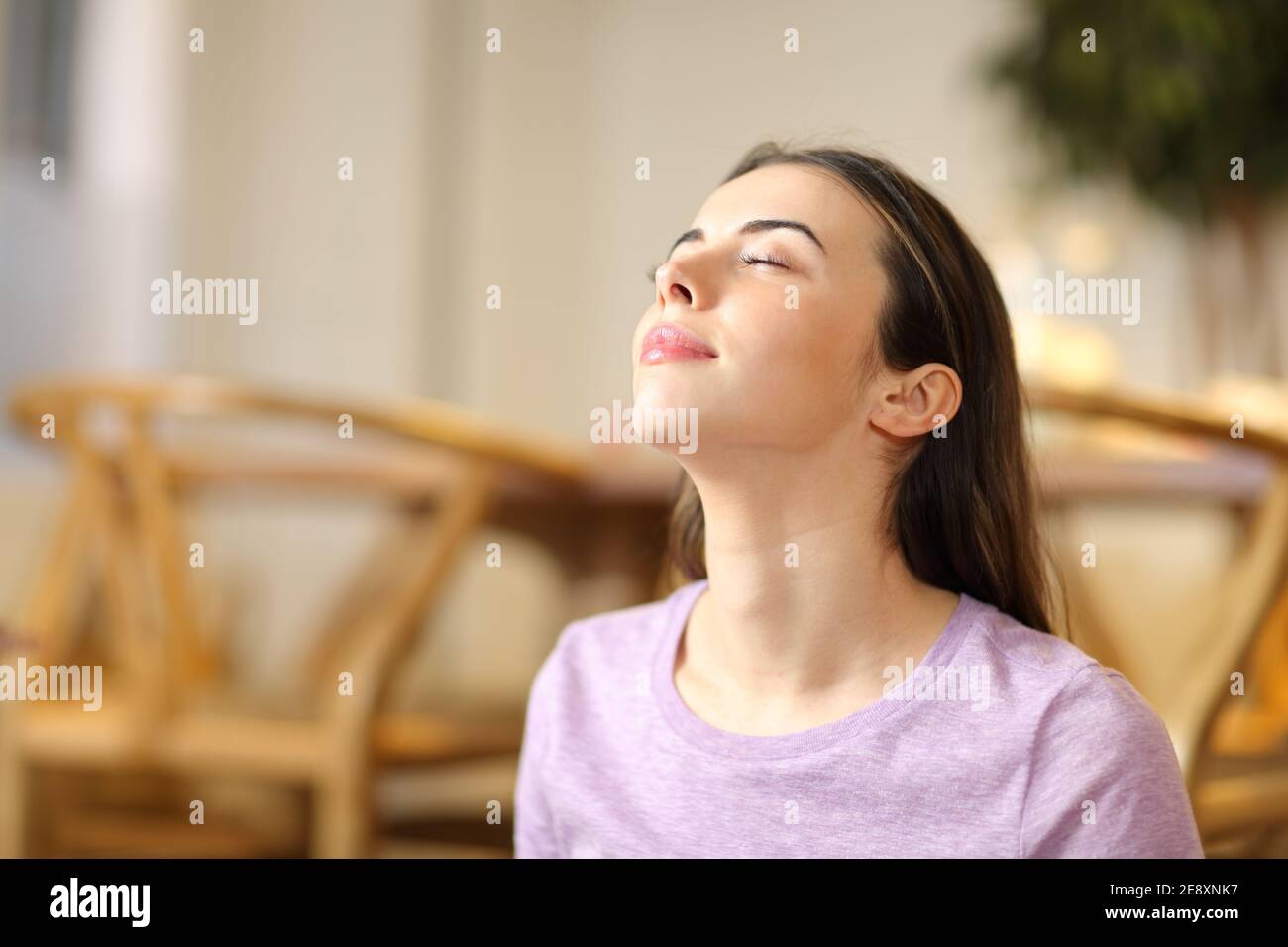 Une femme heureuse respirait de l'air frais et se détendant seule à la maison Banque D'Images