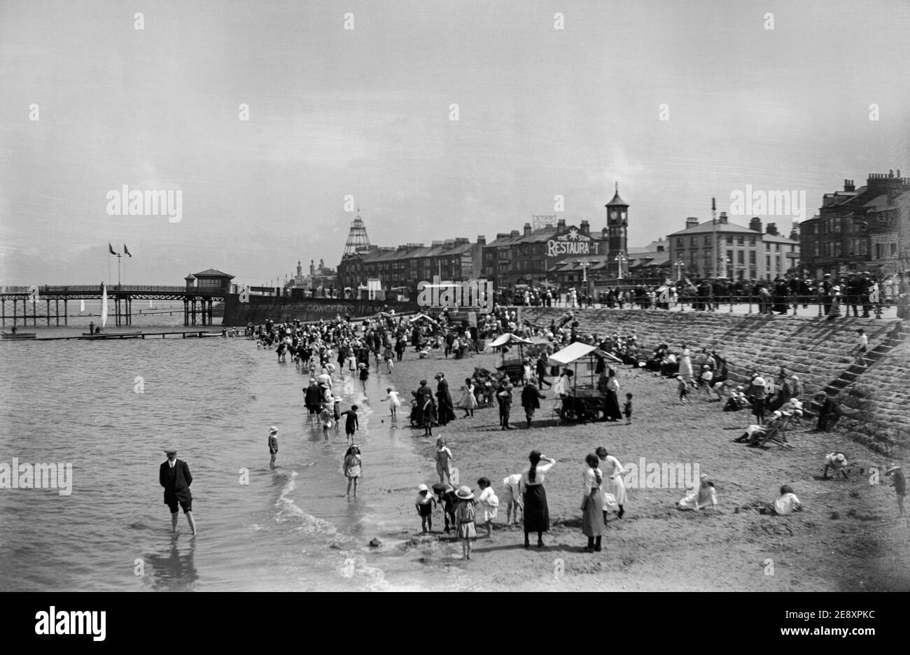 Photographie noir et blanc de la fin de l'époque victorienne montrant des gens qui apprécient leurs vacances sur une plage en Angleterre. Banque D'Images