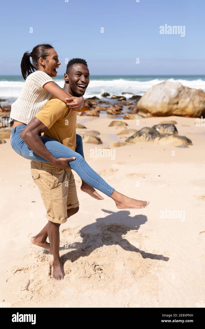 Couple afro-américain qui se trouve sur une plage au bord de la mer Banque D'Images