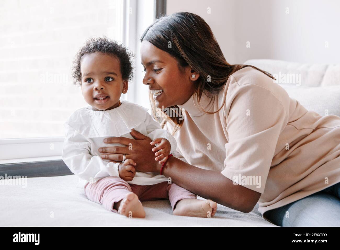 Joyeux Sourire Jeune Mere Indienne Jouant Avec Fille Noire De Bebe Fille La Famille A Melange Les Gens De Course Maman Et Enfant Ensemble Se Serrant A La Maison Authentique Cand Photo