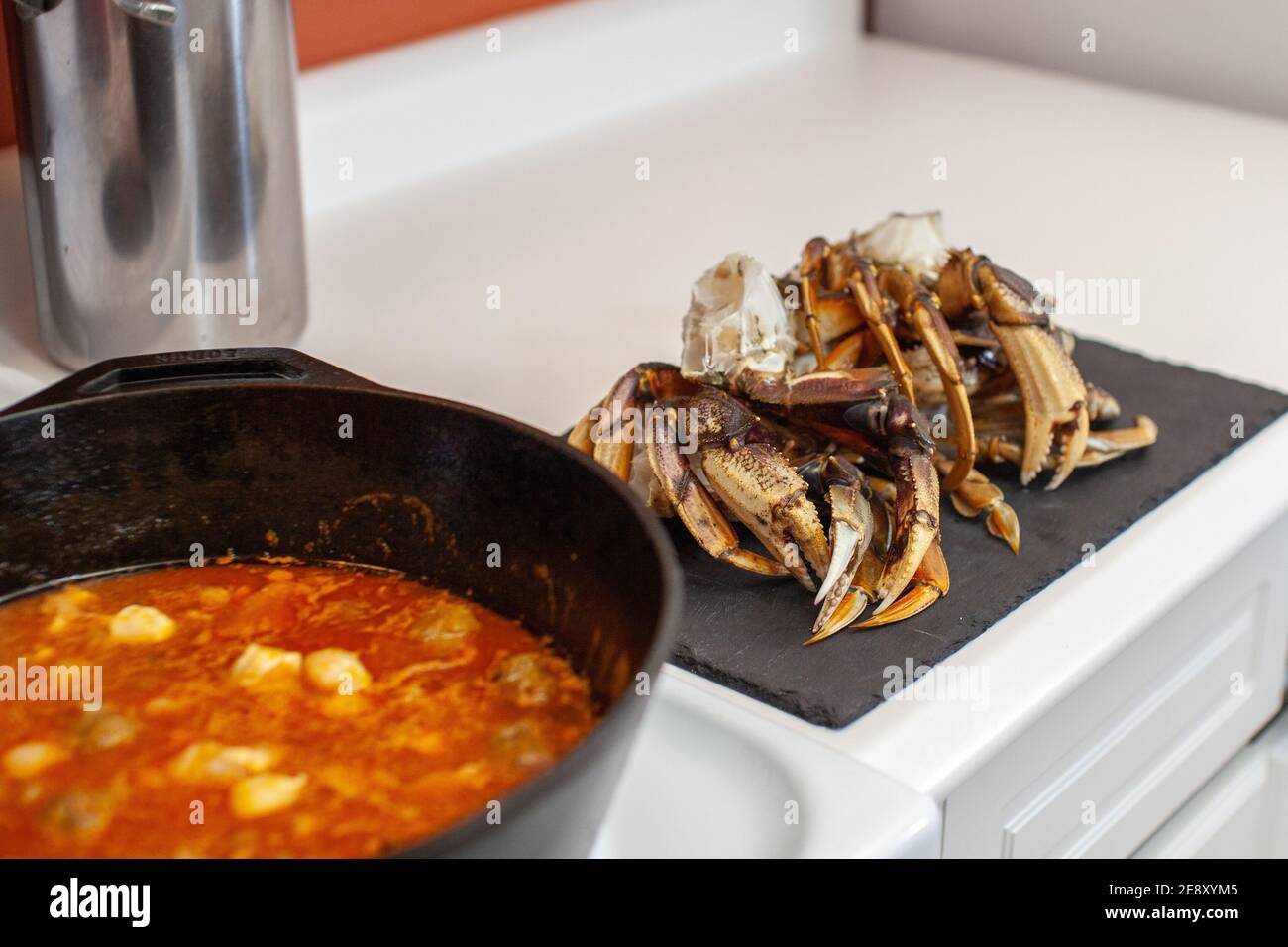 Les pattes de crabe Dungeness sont préparées et prêtes à être placées dans une grande casserole en fonte pour préparer une soupe de fruits de mer pour le dîner Banque D'Images