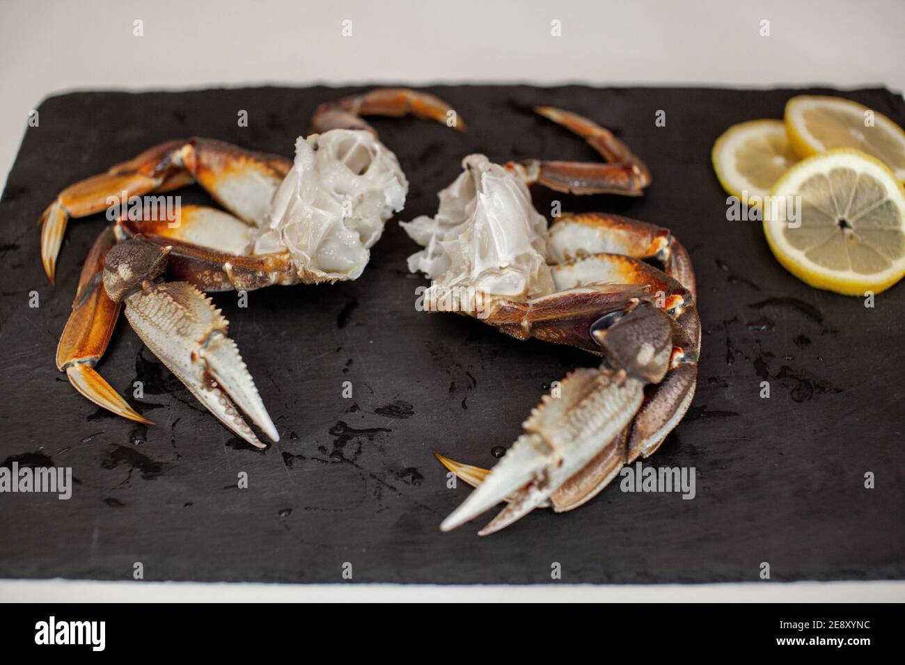 Les pattes de crabe Dungeness crues, nettoyées et non cuites s'assoient sur un plateau dans la cuisine prête à être cuites pour le dîner Banque D'Images