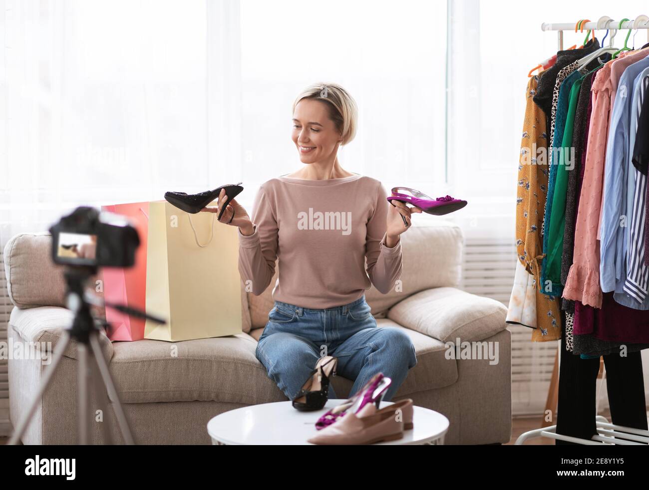 Vidéo de mode. Un influenceur célèbre sur les réseaux sociaux annonçant la nouvelle collection de chaussures devant un appareil photo professionnel Banque D'Images