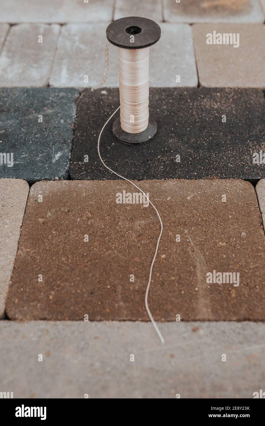 Bobine de marquage du chantier de construction - installation de pavés sur les patios - corde de broyage du fer à inclinaison de constructeur Banque D'Images