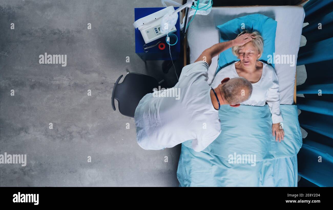 Vue de dessus du médecin et de la patiente avec perfusion IV dans le lit à l'hôpital. Banque D'Images