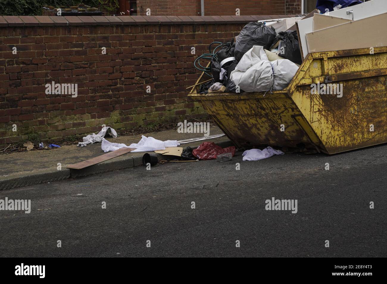Un saut débordant avec les déchets ménagers qui entaillent les trottoirs et les routes avec espace de copie Banque D'Images