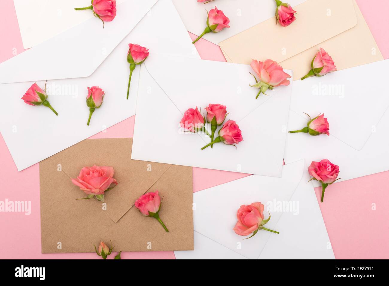 vue de dessus des petites roses de thé sur les enveloppes et les lettres Banque D'Images