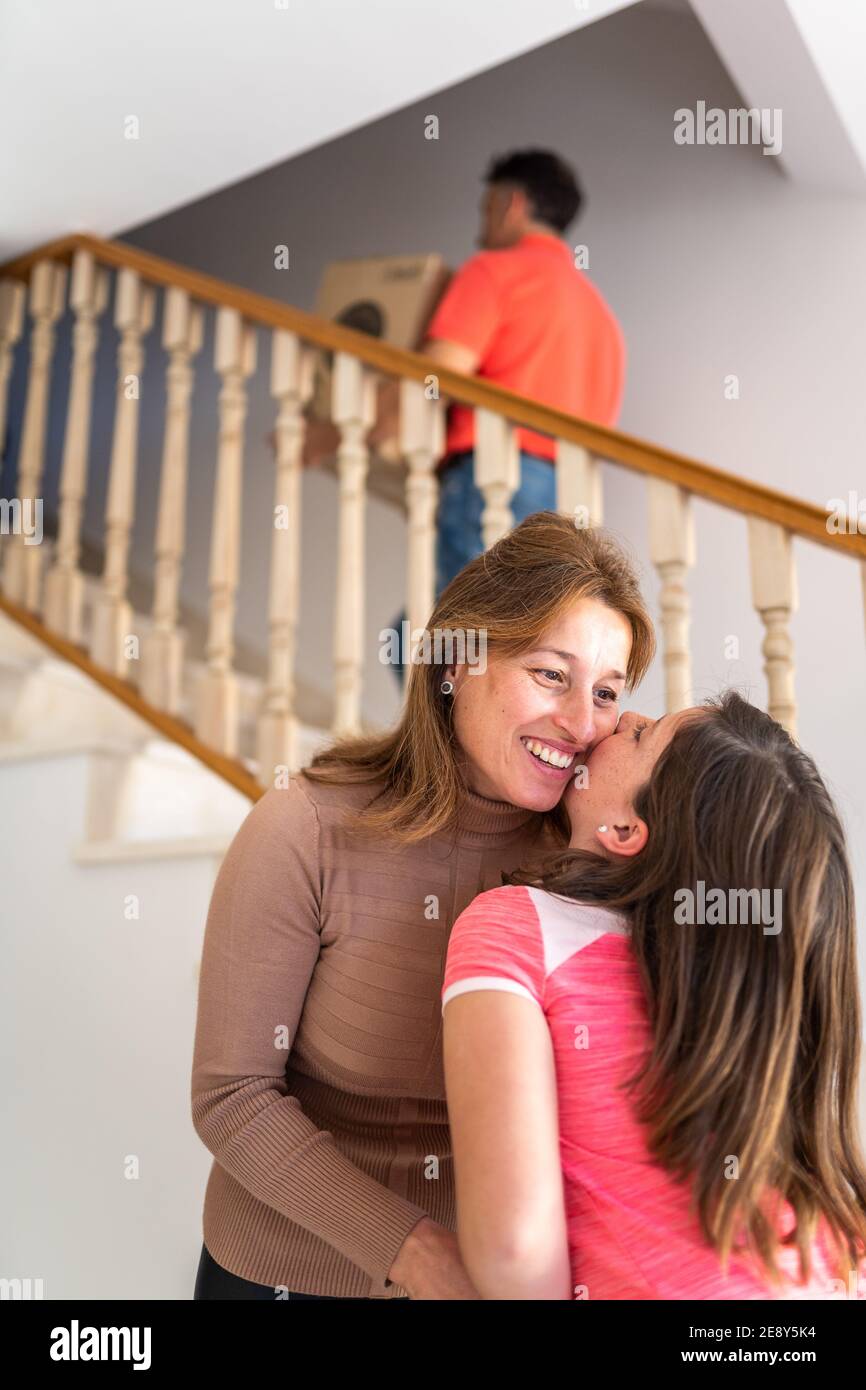 Maman jouant avec sa fille pendant que son père déplace des boîtes dans le nouvelle maison Banque D'Images