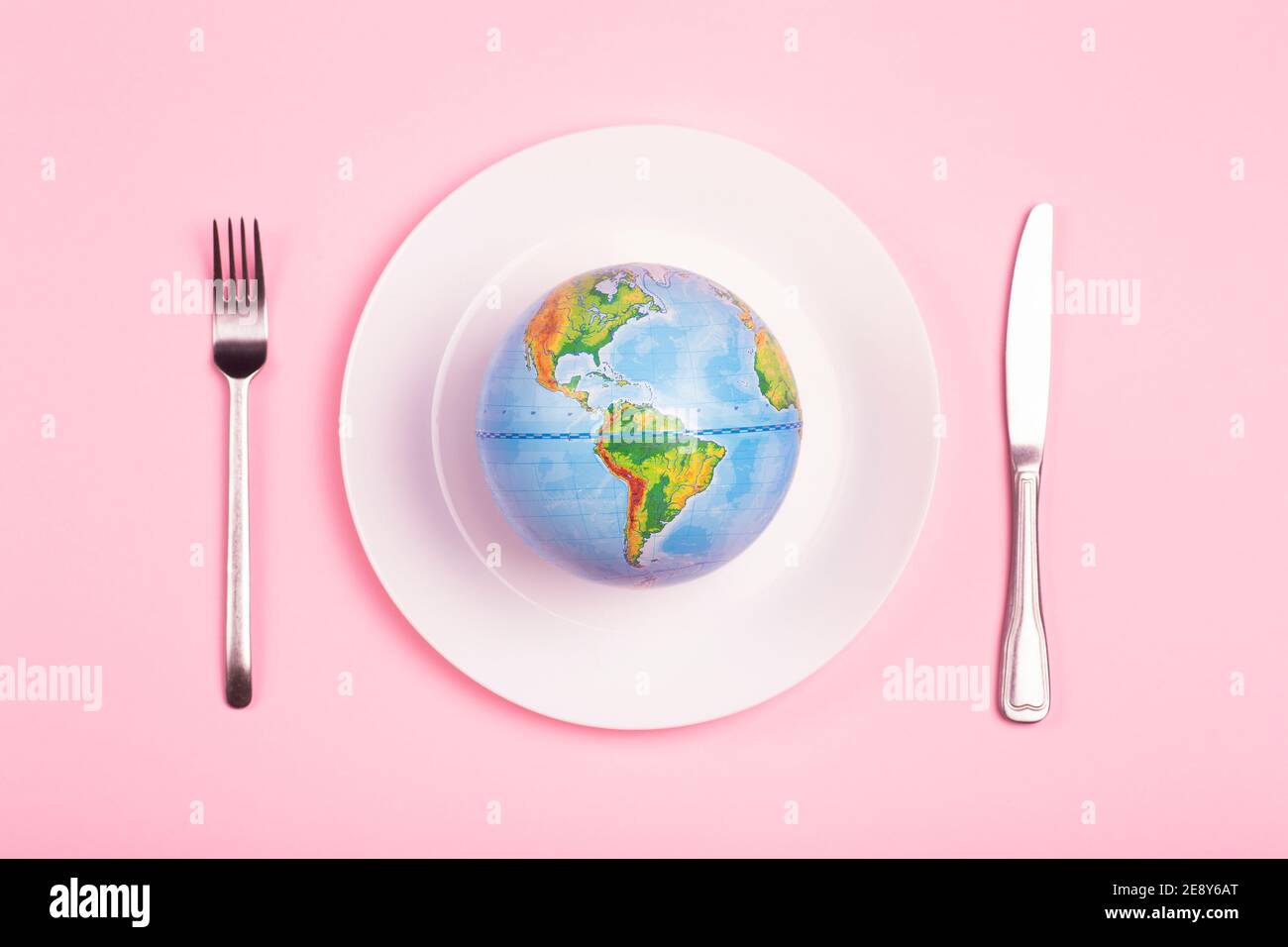 Globe sur une assiette pour les aliments sur fond rose. Pouvoir, économie, politique, mondialisme, faim, pauvreté et concept alimentaire mondial. Banque D'Images
