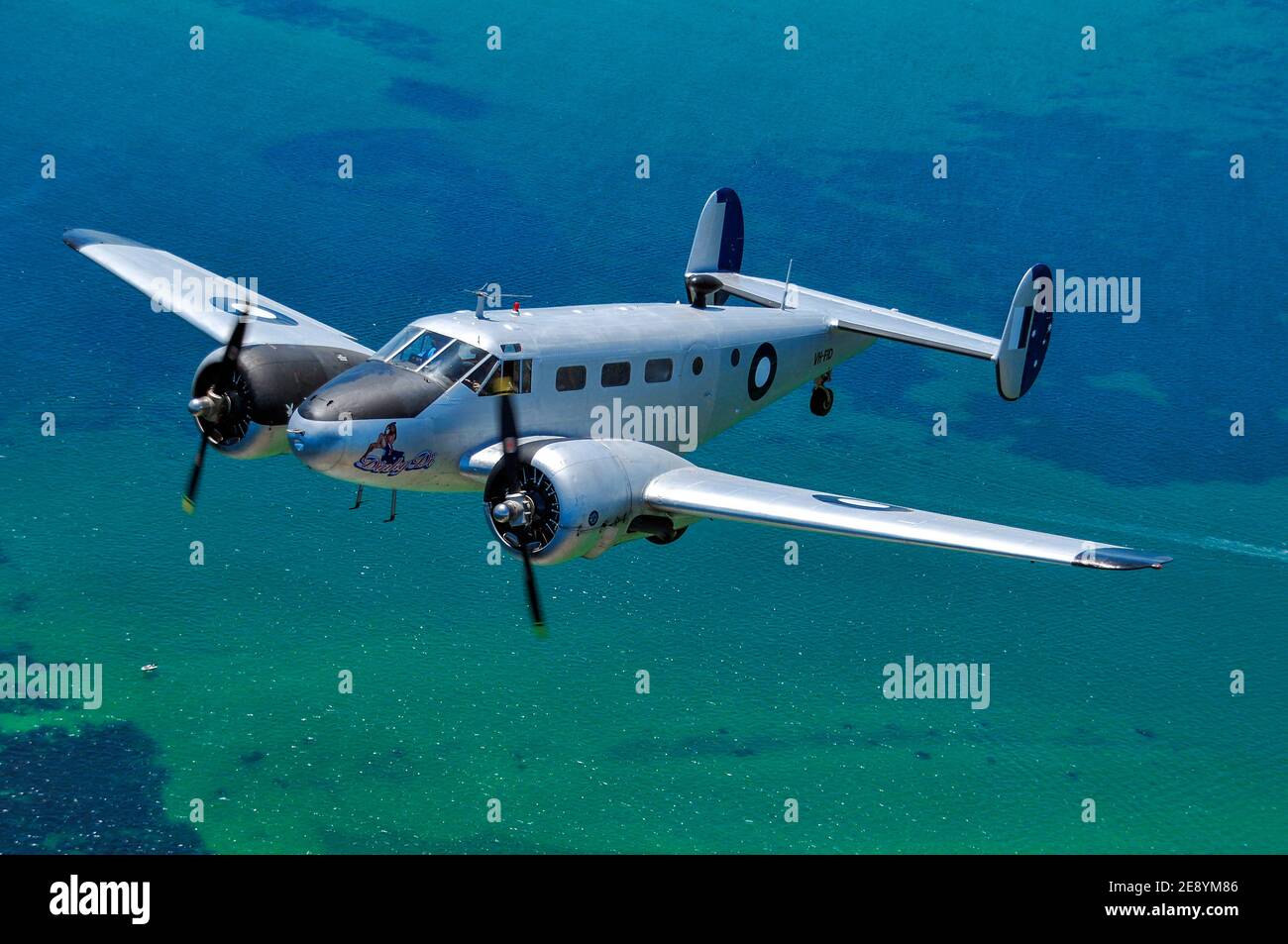 Un avion de transport Beech 18 Expeditor restauré de la deuxième Guerre mondiale au-dessus de l'océan. Banque D'Images