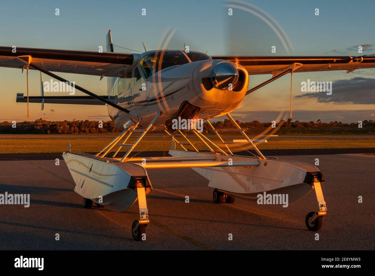 Coucher de soleil illuminant un avion flottant du Cessna 208 Grand Caravan. Banque D'Images