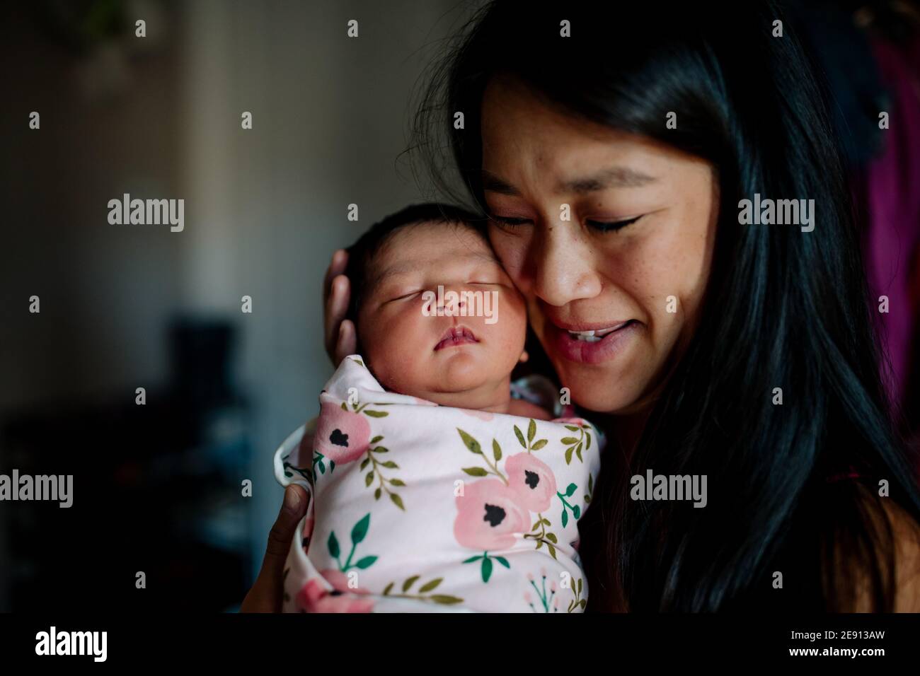 Belle mère asiatique submergée d'amour pour le nouveau-né Banque D'Images