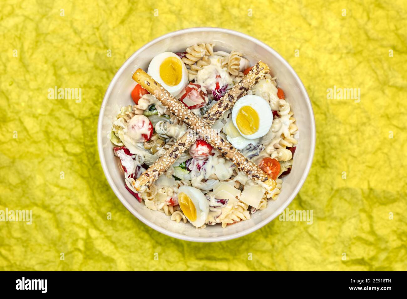 Vue panoramique d'une salade avec pâtes, œufs, légumes et gressins Banque D'Images