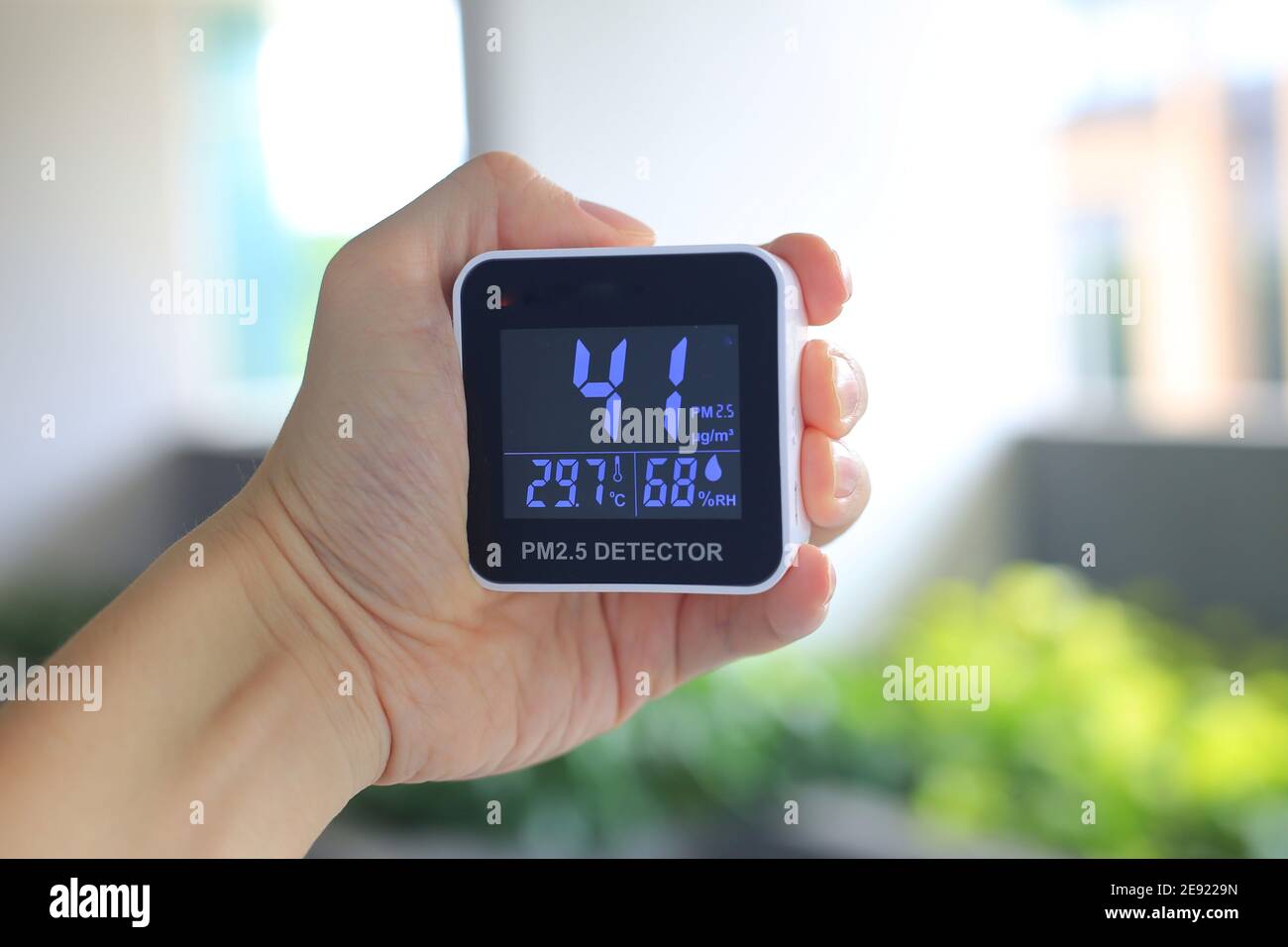 Vérification de la qualité de l'air à l'aide d'un capteur de PM2,5 portatif. Les particules de PM2,5 se dépoussiérant à des substances nocives et malsaines au-delà des normes Banque D'Images